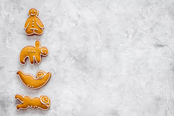 Gingerbread cookies in shape of yoga asanas on stone background top view mock up