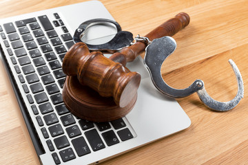 Handcuffs and gavel on laptop
