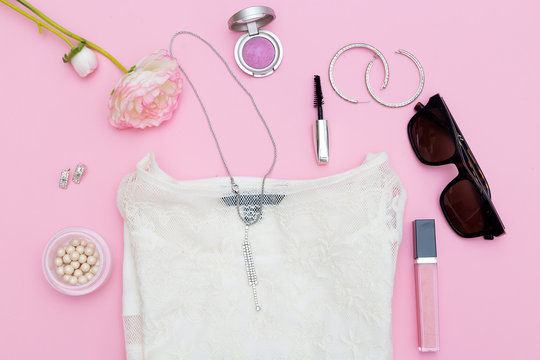 Fashion accessories, cosmetics and clothing on a pink background. Flat lay