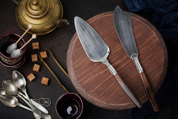 Vintage spatula and knife for cakes on a dark stone or concrete background. Selective focus. Top view. Copy space.