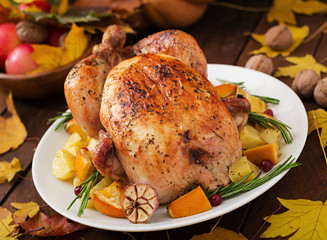 Roasted turkey garnished with cranberries on a rustic style table decorated with pumpkins, orange, apples and autumn leaf. Thanksgiving Day.