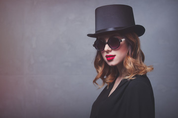 Style and mystique redhead girl in top hat and sunglasses