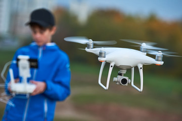 Young man operating of flying drone at sunset
