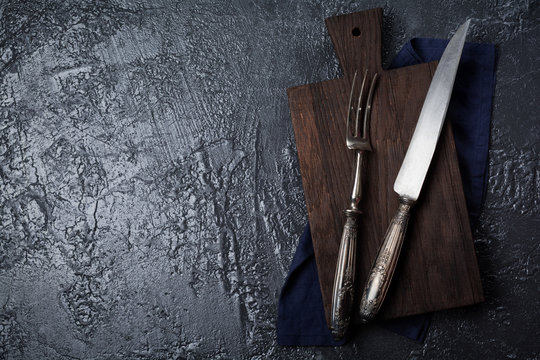 Vintage forks and knives for meat on  gray concrete or stone background. Selective focus. Top view. Copy space.