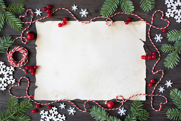 Christmas wooden background with paper, snowflakes, branches tree, red berries and twine in the...