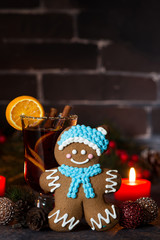 Christmas composition with mulled wine and gingerbread man on dark background, vertical