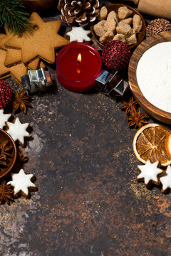 dark background with ingredients for baking Christmas cookies and candle, top view