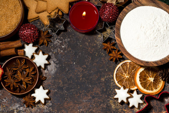 dark background with ingredients for baking Christmas cookies and candle