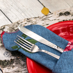 metal fork and knife wrapped in blew napkin close up view