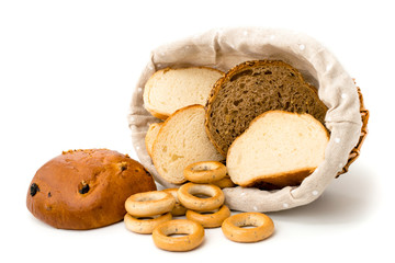 Slices of bread in a basket and scattered the bagels on a white