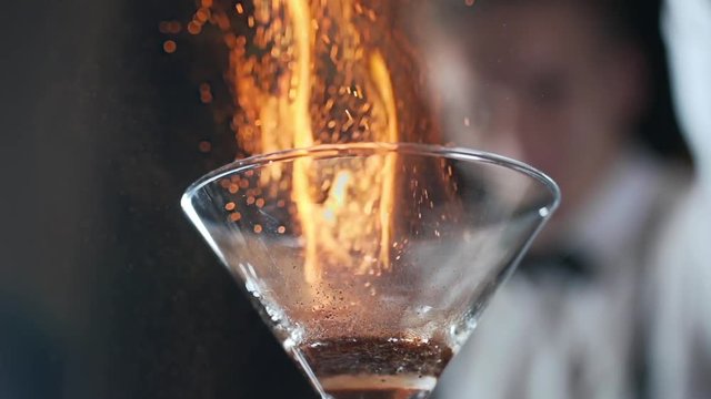 Bartender sets fire to cocktail, burning cinnamon in alcohol drink, 240 frames per second, barman makes drink
