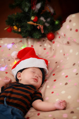 Fototapeta na wymiar sleeping baby wearing Santa hat 