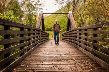 Fototapeta na wymiar hike man with backpack walking in forest nature outdors bridge.