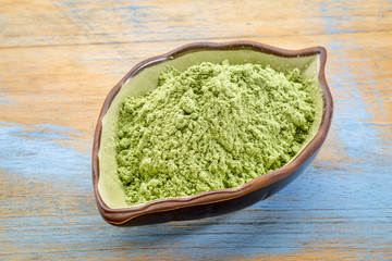 organic barley grass powder in a leaf bowl