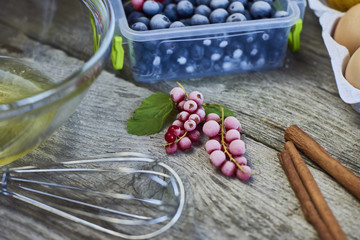 Food ingredients and kitchen utensils for cooking desserts on wooden background