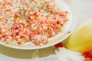 Raw minced meat with rice and spices, fresh vegetables. Ingredients for home cooking.