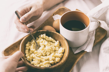 Young man having Breakfast in bed in the morning
