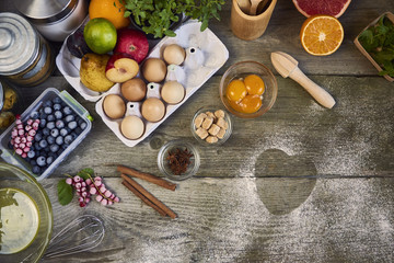 Food ingredients and kitchen utensils for cooking desserts on wooden background