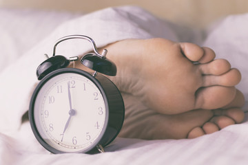 Men's legs, and alarm clock