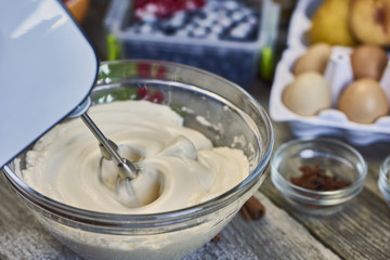 Closeup of electric mixer with whipped smooth dough for cake
