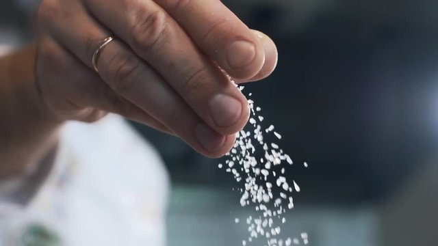 Chef adds salt to the dish, cooking in slow motion, falling liquid in 240 frames per second, cooking food