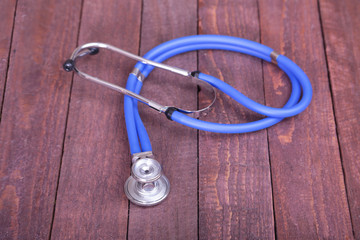 Medical stethoscope and tablets isolated on wooden background