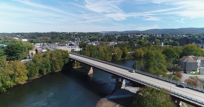 A slowly moving forward aerial shot of the small town of Connellsville, Pennsylvania while traffic travels on the Memorial Boulevard (Rt 119) bridge over the Youghiogheny River.  	