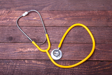 Medical stethoscope and tablets isolated on wooden background