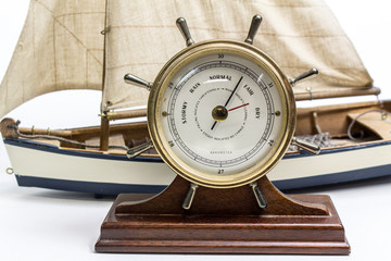 Old weather barometer with a model ship in background