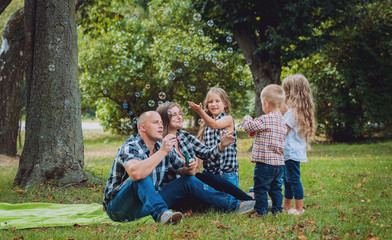 Fototapeta premium Young family with cheerful children in the park