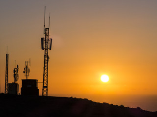 Trasmitter mast, tower in the orange light of the sinking sun.