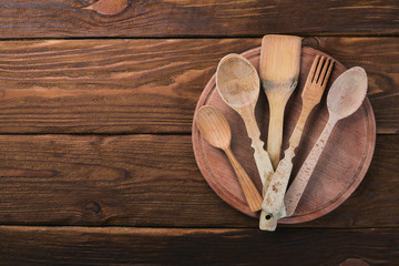 Wooden spoons, forks and shovels. On a wooden background. Top view. Free space for your text.