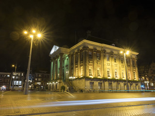 Fototapeta na wymiar city hall illuminated at night in dutch town of groningen in the north of the netherlands on central square