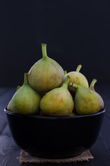 Figs in bowl on black background.