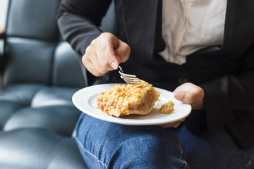 Asian business woman in relax time and eating apple pie in coffee shop. Hand holding  spoon used to eat pie. Apple pie, regional variation apple tart, which the principal filling ingredient is apple.