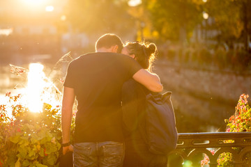 Verliebtes junges Pärchen im Sonnenuntergang auf einer Brücke 