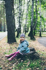 portrait of a little curly-haired girl in the woods