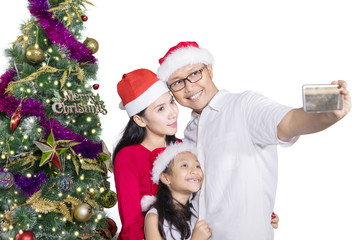 Family taking selfie picture near Christmas tree