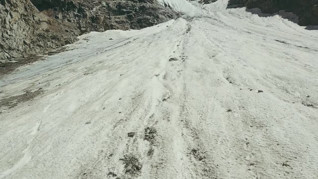 Aerial shooting from flying drone mountain glacier on summer day
