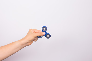 young man holding with a fidget spinner close up