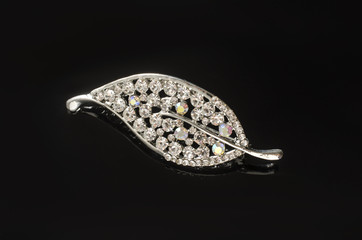 silver brooch leaf with diamonds isolated on black background