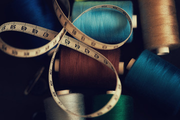 Pile of colorful spools of thread and measuring meter 