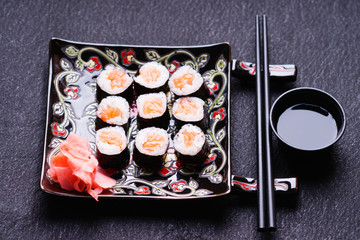 Sushi rolls with salmon, ginger, chopsticks and soy sauce 