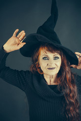 halloween old woman with long red hair in witch hat