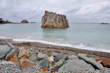 Gros rocher dans l'eau sur une plage de Plougrescant en Bretagne © aquaphoto