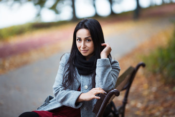 Fototapeta na wymiar Portrait of a Stylish Pretty Young Woman in Autumn Fashion Coat outdoors.