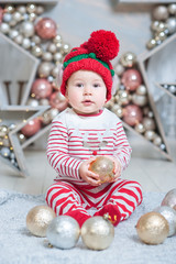 Little boy in elf hat waiting for a Christmas holding tree decoration