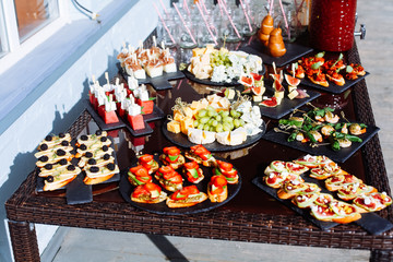 Catering banquet table with different food snacks and appetizers