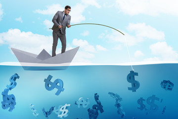 Businessman fishing dollars money from paper boat ship
