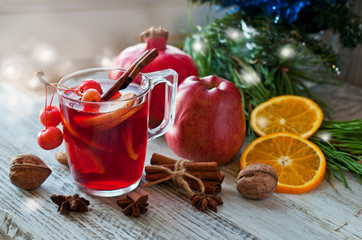Mulled wine, winter drink, fruit and Christmas decor on a wooden background. Festive cocktail
